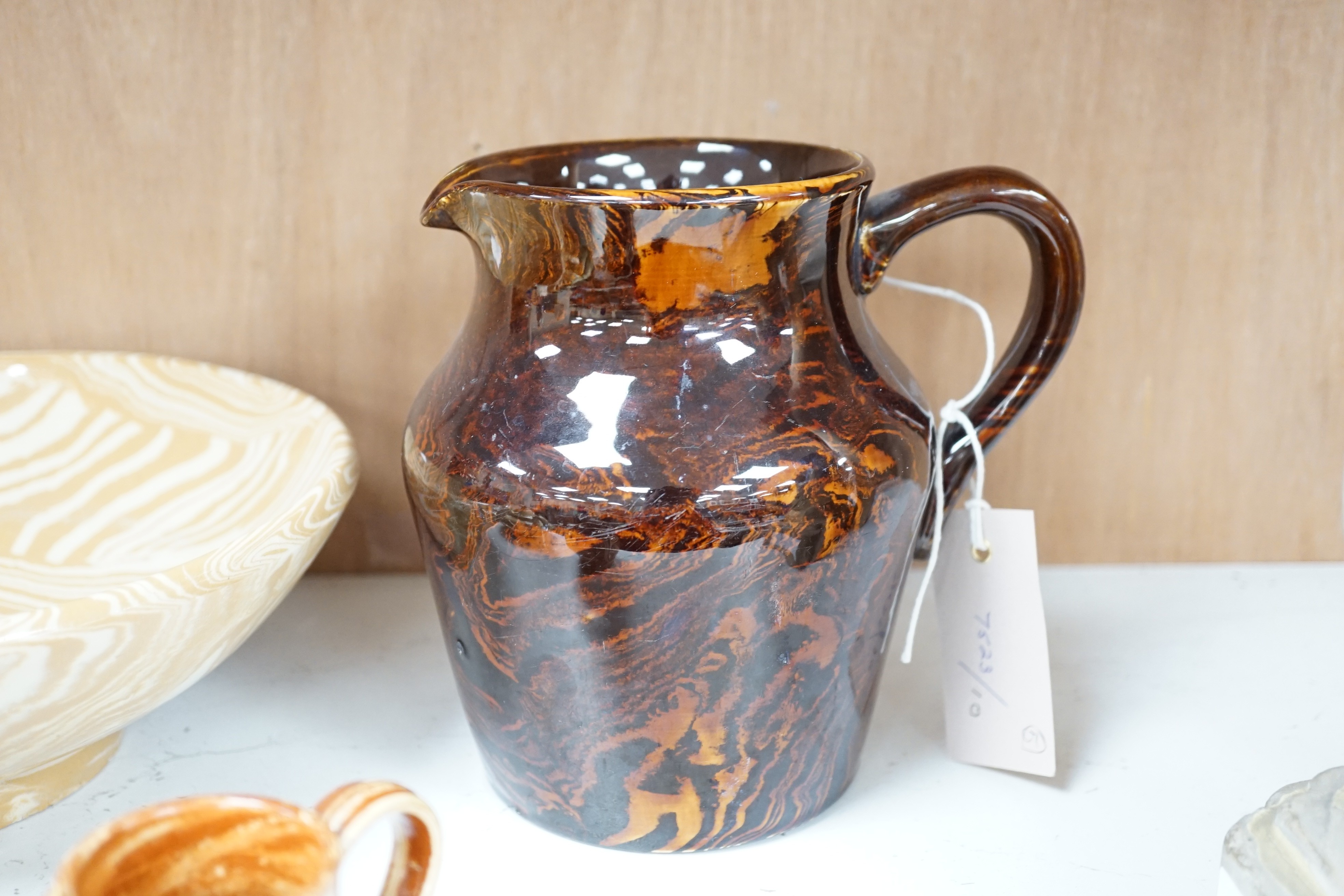 A Victorian solid agate ware pottery jug, a similar bowl and pair of miniature jugs, an unusual Doulton Lambeth stoneware jug and a small relief-moulded teapot, Doulton jug, 19cms high